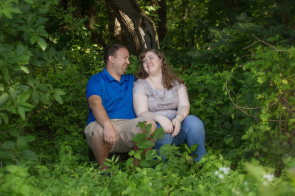 Engaged couple enjoying a laugh in the woods